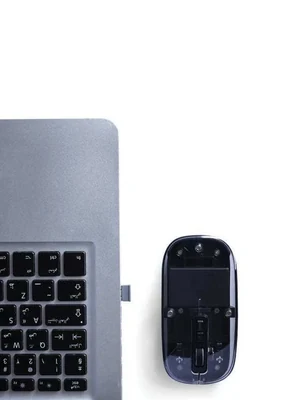Nuvello Transparent Rechargeable Wireless Mouse, transparent mouse beside laptop