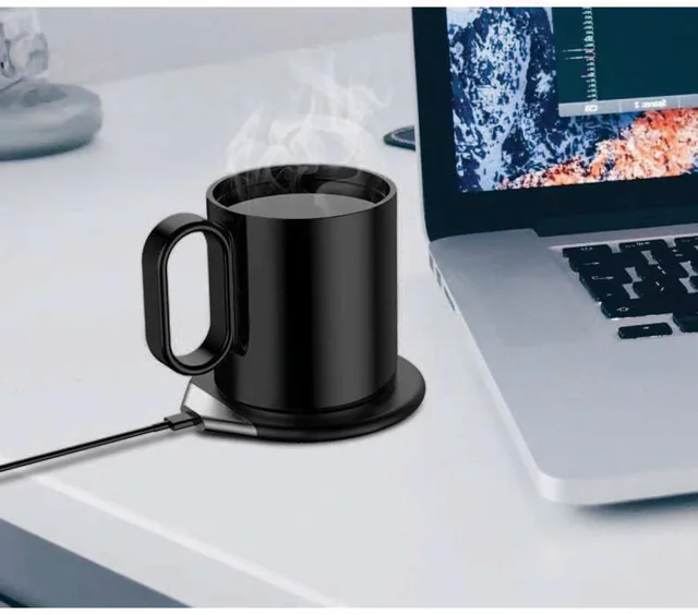 Hans Larsen Hedrin Mug Warmer and Wireless Charger, Black heating mug on its warmer beside a laptop