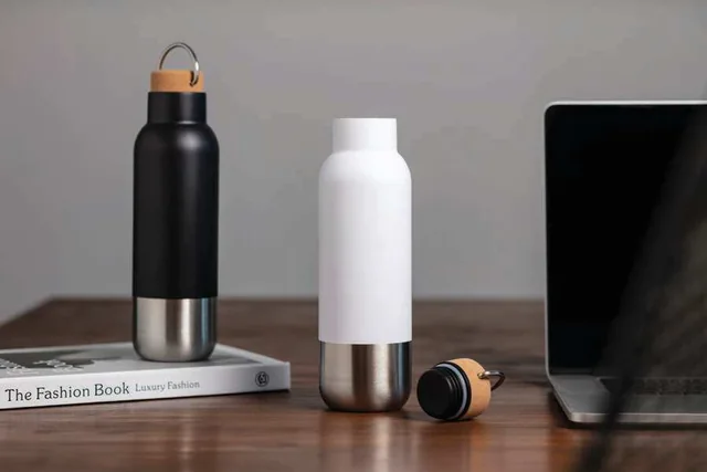Hans Larsen Avrien 650ml Vacuum Bottle, Black and white recycled steel bottles on a desk